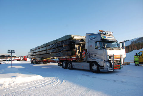 Limträelement lastade på trailerbil för transport till byggarbetsplatsen.
